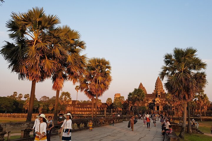 Angkor Wat at sunset hours with the tourist visiting. The golden hours moment reflection to the Angkor Wat look so gold.